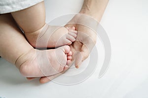 Mother hand touching and holding her Little Baby feet