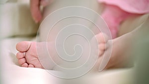 Mother hand touching infant baby foot. Family tenderness. Maternity care