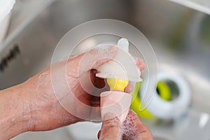 mother hand washing the baby nipple of milk bottle