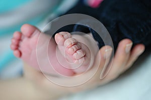 Mother hands holding baby feet
