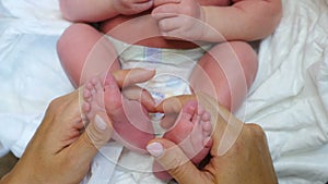 Mother hands holding cute tiny little baby feet feeling love and tenderness enjoying motherhood. Baby kid feet in parent