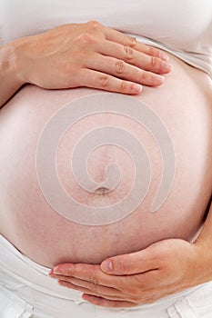 Mother hands holding pregnant belly