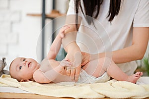 Mother hands put diaper on baby girl