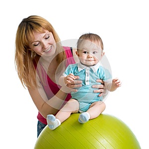 Mother with happy baby doing exercises with gymnastic ball. Concept of caring for children health.