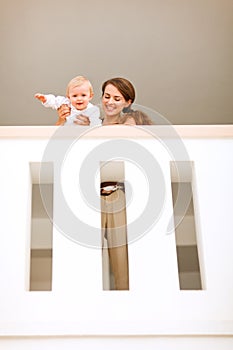 Mother with happy baby looking down from railing
