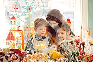 Mother with happy children in the candy store
