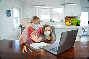 Mother and happy daughter studying at home during coronavirus self isolation and school closures