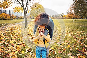 Mother and happy son child boy walking in autumn park