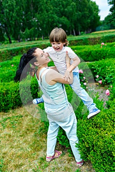 Mother and happy son playing in summer park