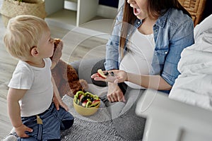 Mother having a fruity snack for her toddler baby