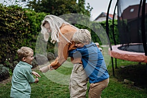 Mother having fun with sons in the garden, bonding moment. Concept of Mother& x27;s Day, and motherly love.