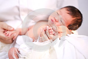 The mother held the baby in her hand. Mom holding small baby hand. Woman hands holding newborn baby hand