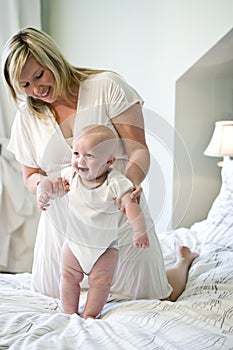 Mother helping baby learn to walk