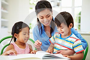 Mother Helping Children With Homework photo