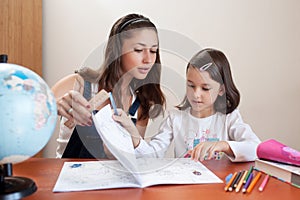 Mother helping daughter do homework