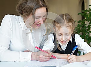 Mother helping daughter with homework.