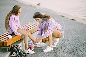 Mother helping daughter to dress rollers at park