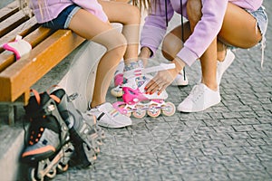 Mother helping daughter to dress rollers at park