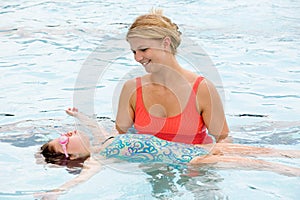 Mother Helping Daughter To Float on Her Back