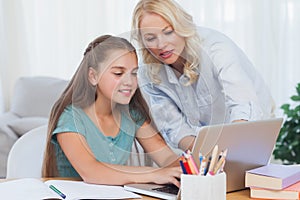 Mother helping her daughter to do homework