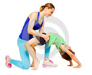 Mother helping her kid son making a crab position