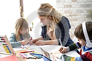 Mom helping her kids with homeschooling during the lockdown photo