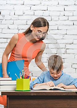 Mother helping her son to do the school homework