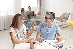 Mother helping her teenager son with homework