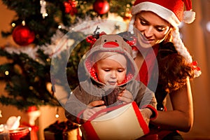 Mother helping interested baby open present box