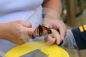 Mother helping put a butterfly on child