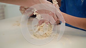 Mother helping son cooking dough. Woman teaching kids cooking cake