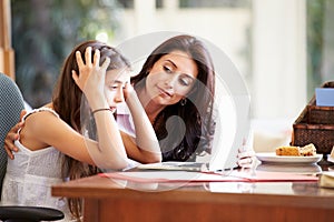 Mother Helping Stressed Teenage Daughter Looking At Laptop