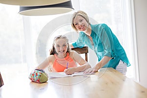 Mother helping teenaged girl with homework