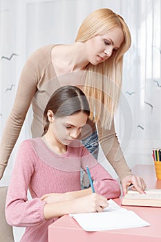 Mother helps daughter with the home work