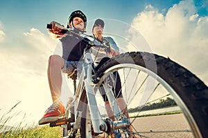 Mother helps her little son start to ride a bicycle