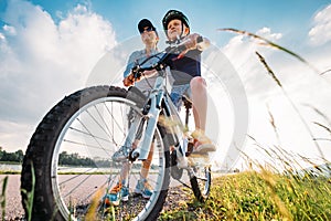 Mother helps her little son start to ride a bicycle