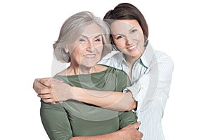 Mother and her adult daughter hugging isolated on white