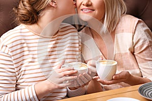 Mother and her adult daughter spending time in cafe, closeup