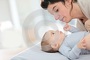 Mother and her baby boy cuddling on a changing table