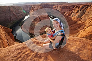 A mother and her baby boy are sitting at the edge