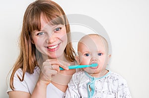 Mother and her baby brushing teeth together