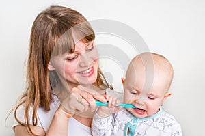 Mother and her baby brushing teeth together