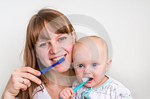 Mother and her baby brushing teeth together