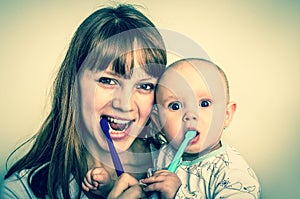 Mother and her baby brushing teeth together - retro style