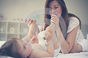 Mother with her baby at home. Mother changing diaper her little