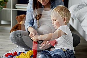 Mother and her baby playing with toy blocks