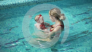 Mother with her baby in the pool