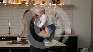 Mother and her baby son having fun and playing at home. Little kid 2 years old play with his mom arms at home near a big