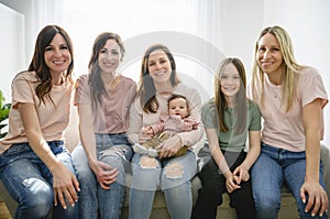 Mother with her baby son on sofa with her girls friends