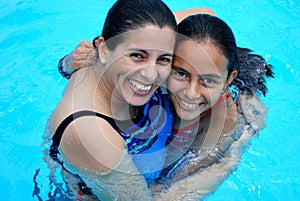 Mother with her beautiful daughter in the pool.
